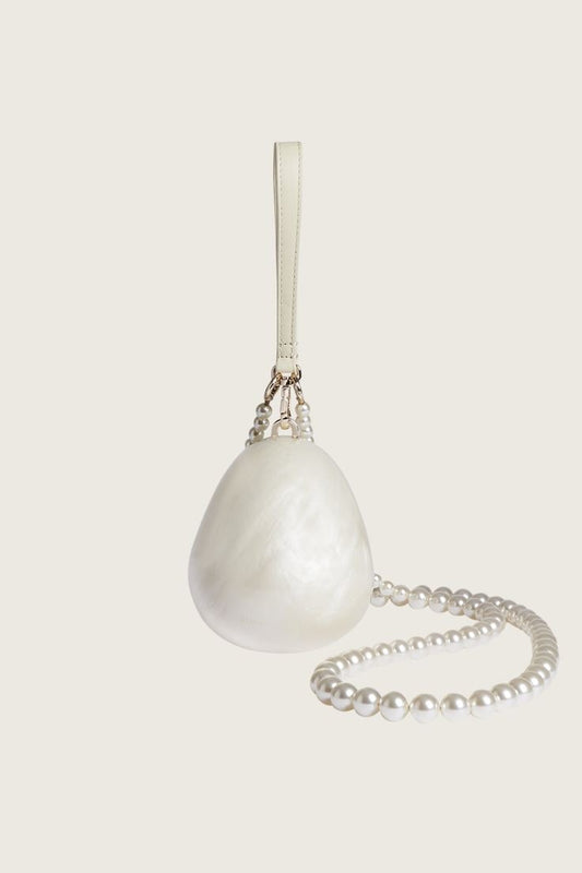 A white faux pearl handbag with a satin lining and a metallic clasp, designed for special occasions.