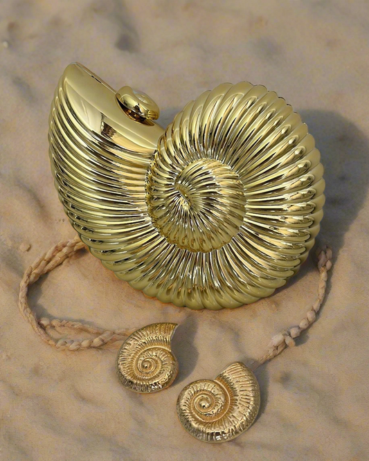 A gold-tone seashell-shaped handbag with a ribbed, spiral pattern. The bag appears to have a hard-shell body and a gold chain strap.